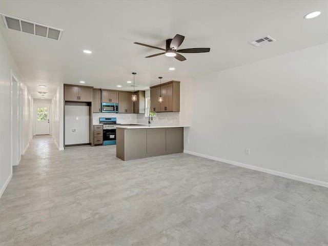 1609 NE 26th St, Oklahoma City, OK 73111 - kitchen with stainless steel microwave, range with electric stovetop, open floor plan, ceiling fan, and recessed lighting