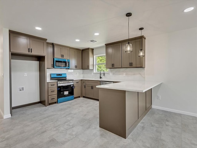 1609 NE 26th St, Oklahoma City, OK 73111 - kitchen with stainless steel appliances, a peninsula, decorative backsplash, light countertops, and hanging light fixtures