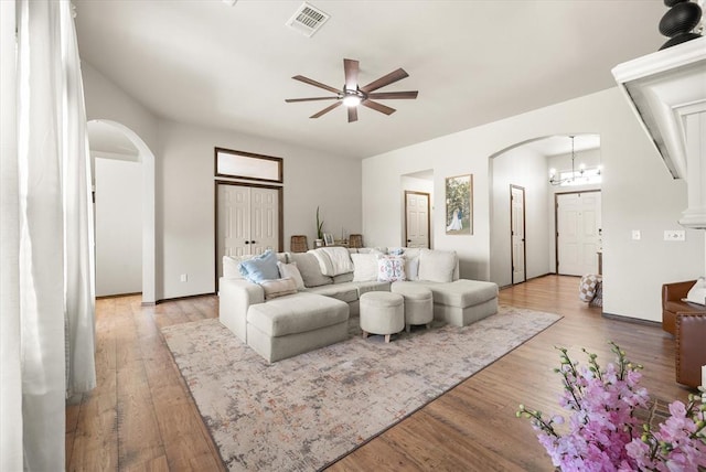18200 Allora Dr, Edmond, OK 73012 - living area with arched walkways, ceiling fan, and light wood-type flooring