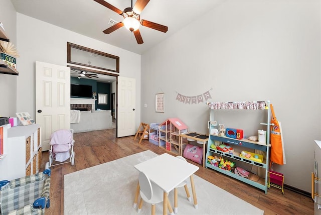 18200 Allora Dr, Edmond, OK 73012 - rec room featuring ceiling fan, a fireplace, and wood finished floors
