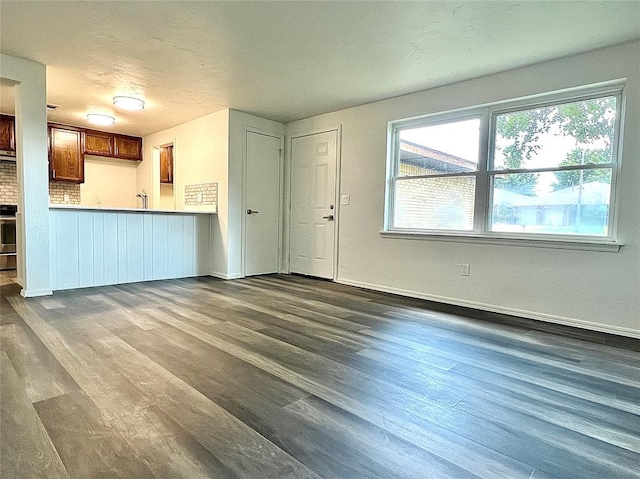 12519 SW 2nd St, Yukon, OK 73099 - unfurnished living room with dark wood-type flooring and a wainscoted wall