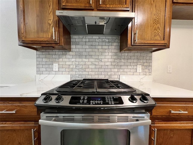 12519 SW 2nd St, Yukon, OK 73099 - kitchen with gas range, range hood, tasteful backsplash, brown cabinets, and light countertops