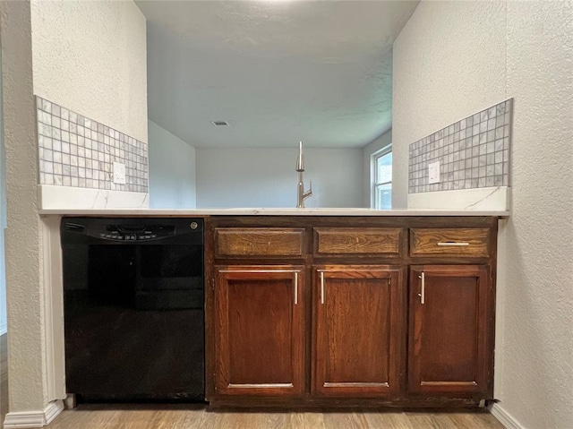 12517 SW 2nd St, Yukon, OK 73099 - kitchen featuring black dishwasher, a textured wall, light wood finished floors, light countertops, and a peninsula