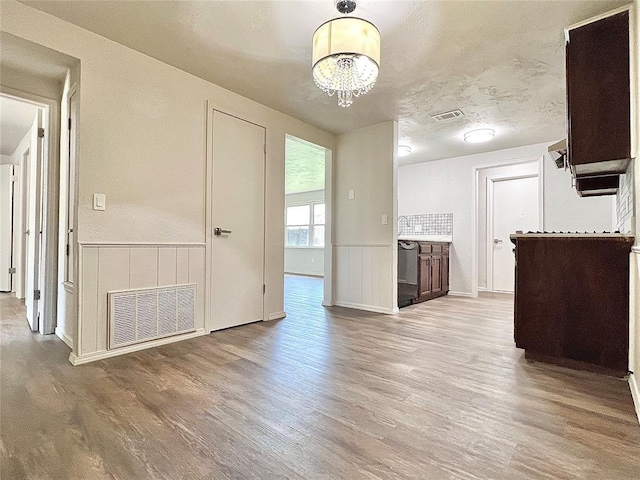 12517 SW 2nd St, Yukon, OK 73099 - kitchen featuring wood finished floors, a chandelier, wainscoting, and dishwasher