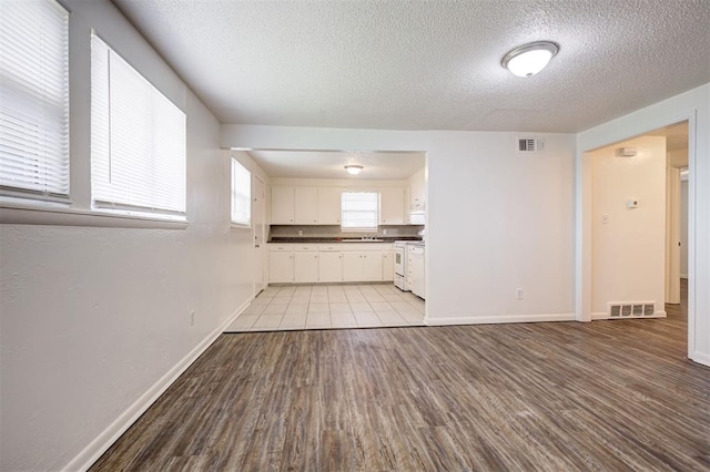 4025 Parkwoods Ln, Midwest City, OK 73110 - unfurnished living room featuring a textured ceiling and light wood-style floors