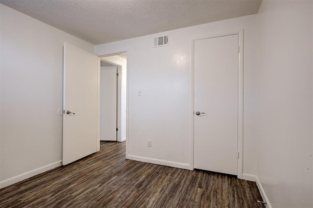 4025 Parkwoods Ln, Midwest City, OK 73110 - unfurnished bedroom with wood finished floors and a textured ceiling