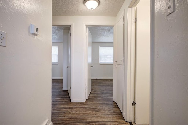 4025 Parkwoods Ln, Midwest City, OK 73110 - corridor with a textured ceiling, dark wood-style flooring, and plenty of natural light