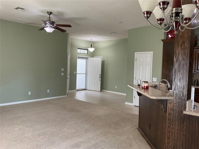 10201 Pinckney Ct, Oklahoma City, OK 73162 - kitchen featuring a kitchen breakfast bar, light colored carpet, ceiling fan, dark brown cabinetry, and decorative light fixtures