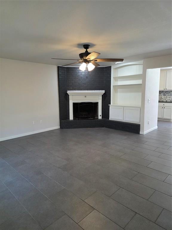 8813 Aaron Dr, Oklahoma City, OK 73132 - unfurnished living room with ceiling fan, a fireplace, and dark tile patterned flooring