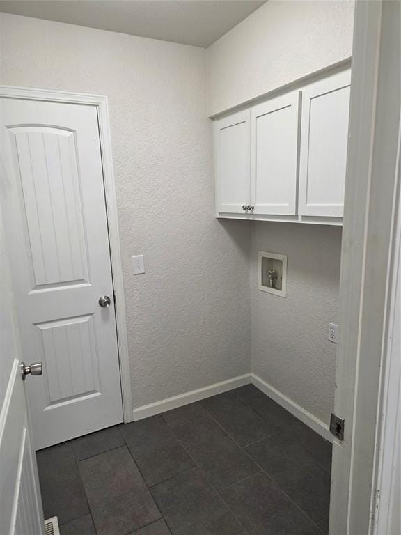 8813 Aaron Dr, Oklahoma City, OK 73132 - laundry room with dark tile patterned floors, hookup for a washing machine, and cabinet space