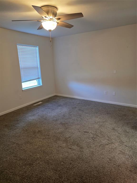 8813 Aaron Dr, Oklahoma City, OK 73132 - unfurnished room featuring dark carpet and a ceiling fan