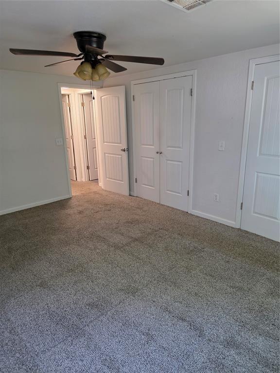 8813 Aaron Dr, Oklahoma City, OK 73132 - unfurnished bedroom featuring carpet floors, a ceiling fan, and a closet
