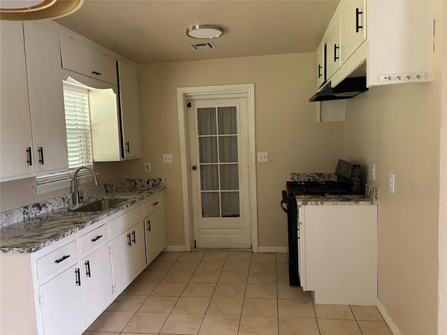 3305 N Mueller Ave, Bethany, OK 73008 - kitchen with range with gas stovetop, under cabinet range hood, light tile patterned floors, light stone countertops, and white cabinets
