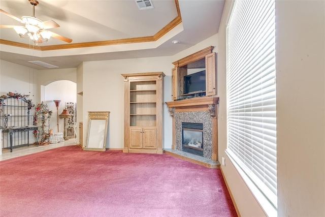 1308 River Birch Dr, Yukon, OK 73099 - unfurnished living room with a tiled fireplace, carpet floors, ceiling fan, ornamental molding, and arched walkways