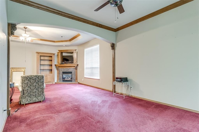 1308 River Birch Dr, Yukon, OK 73099 - unfurnished living room featuring a ceiling fan, arched walkways, a glass covered fireplace, carpet, and crown molding