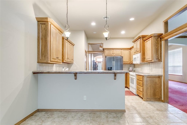 1308 River Birch Dr, Yukon, OK 73099 - kitchen featuring white appliances, a peninsula, a breakfast bar area, decorative backsplash, and recessed lighting