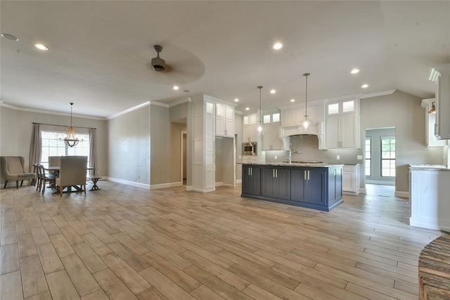 3019 Winding Creek Ln, Piedmont, OK 73078 - kitchen with stainless steel microwave, white cabinets, ceiling fan, tasteful backsplash, and ornamental molding