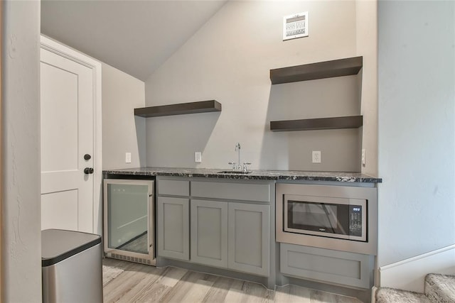 3019 Winding Creek Ln, Piedmont, OK 73078 - kitchen featuring open shelves, stainless steel microwave, beverage cooler, gray cabinetry, and vaulted ceiling