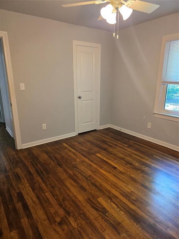 6101 NW 48th St, Warr Acres, OK 73122 - spare room featuring ceiling fan and dark wood-style flooring