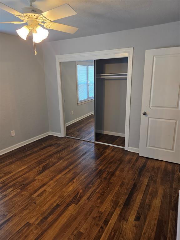 6101 NW 48th St, Warr Acres, OK 73122 - unfurnished bedroom featuring dark wood finished floors, a closet, and a ceiling fan