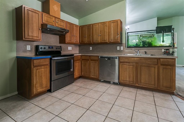 1709 NW 147th St, Edmond, OK 73013 - kitchen with appliances with stainless steel finishes, under cabinet range hood, brown cabinetry, lofted ceiling, and backsplash