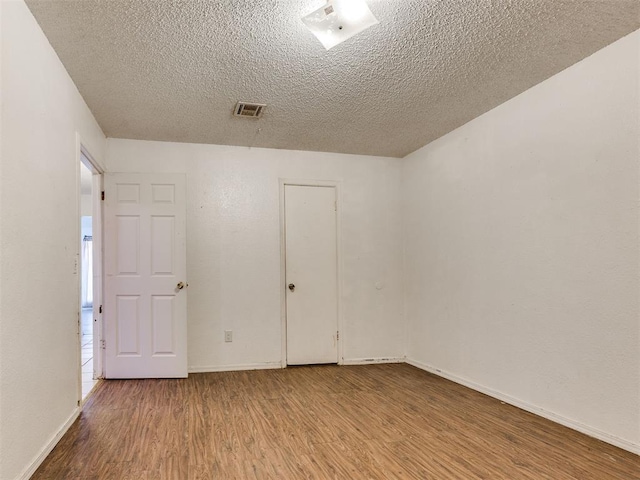 218 Windsor Way, Midwest City, OK 73110 - empty room with wood finished floors and a textured ceiling