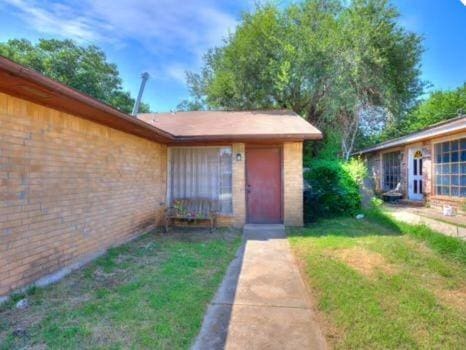 218 Windsor Way, Midwest City, OK 73110 - doorway to property with a yard and brick siding