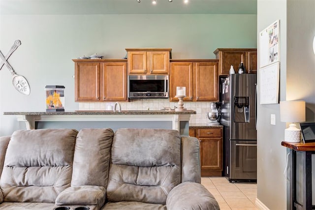 2500 SE 93rd St, Moore, OK 73160 - kitchen with appliances with stainless steel finishes, open floor plan, light tile patterned flooring, and decorative backsplash
