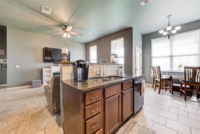 2500 SE 93rd St, Moore, OK 73160 - kitchen featuring stainless steel dishwasher, open floor plan, a ceiling fan, dark stone counters, and a chandelier