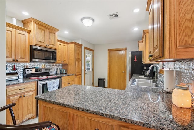 720 N Main St, Blanchard, OK 73010 - kitchen with stainless steel appliances, a peninsula, decorative backsplash, recessed lighting, and dark stone counters