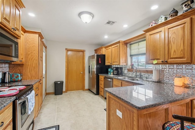 720 N Main St, Blanchard, OK 73010 - kitchen featuring stainless steel appliances, tasteful backsplash, dark stone countertops, brown cabinetry, and recessed lighting