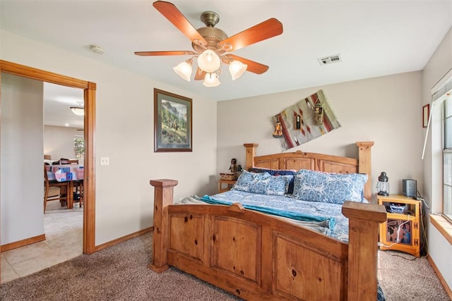 720 N Main St, Blanchard, OK 73010 - bedroom featuring light carpet, a ceiling fan, and light tile patterned floors