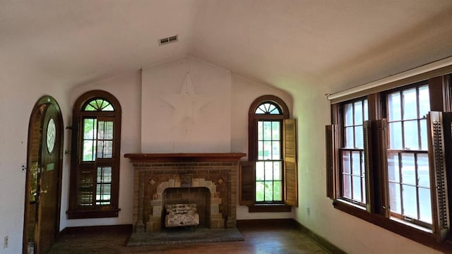2609 NW 14th St, Oklahoma City, OK 73107 - unfurnished living room featuring vaulted ceiling, a fireplace, and wood finished floors