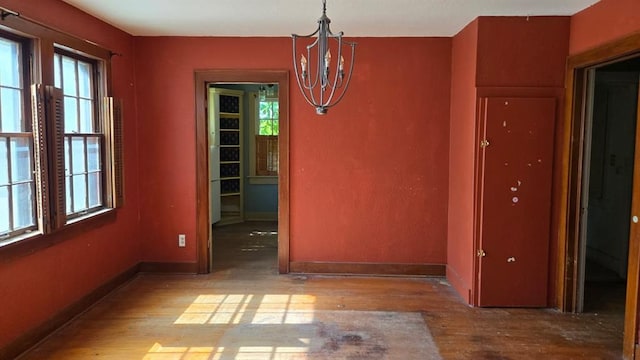 2609 NW 14th St, Oklahoma City, OK 73107 - unfurnished dining area featuring wood finished floors, plenty of natural light, and a chandelier