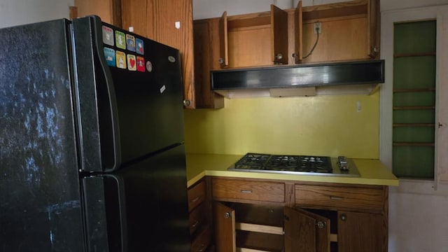 2609 NW 14th St, Oklahoma City, OK 73107 - kitchen with freestanding refrigerator, brown cabinetry, and gas stovetop