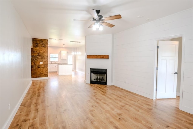 621 SW 7th St, Moore, OK 73160 - unfurnished living room featuring a ceiling fan, light wood finished floors, and a fireplace