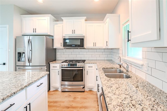621 SW 7th St, Moore, OK 73160 - kitchen featuring appliances with stainless steel finishes, white cabinetry, light wood finished floors, light stone counters, and recessed lighting