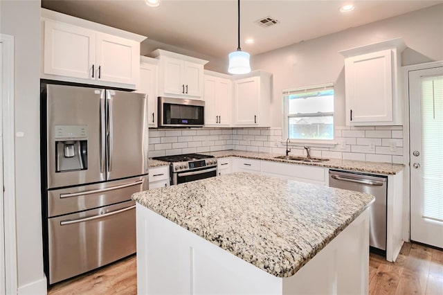 621 SW 7th St, Moore, OK 73160 - kitchen with stainless steel appliances, white cabinets, light wood-style flooring, and recessed lighting