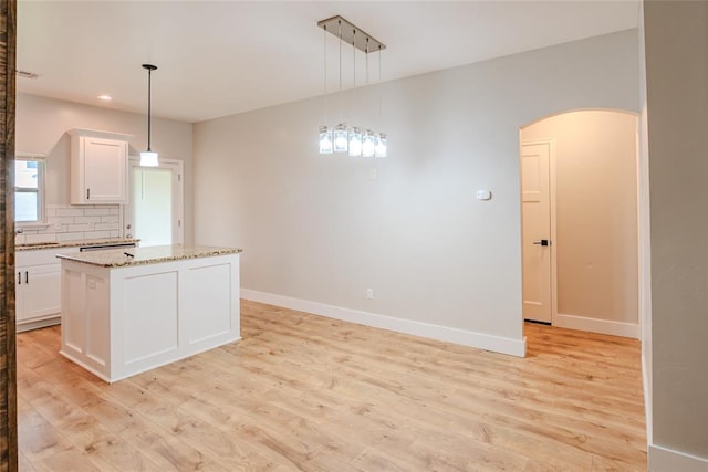 621 SW 7th St, Moore, OK 73160 - kitchen with arched walkways, light wood finished floors, backsplash, recessed lighting, and white cabinetry