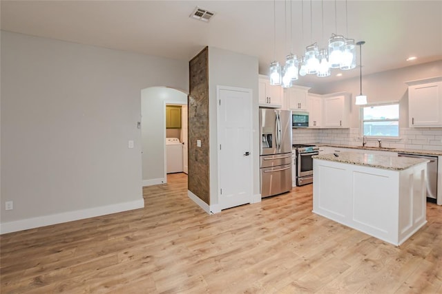 621 SW 7th St, Moore, OK 73160 - kitchen featuring stainless steel appliances, arched walkways, light wood-style flooring, white cabinets, and recessed lighting