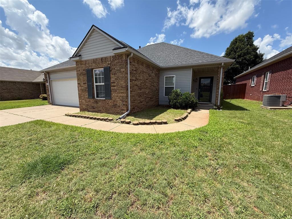 5913 SE 67th St, Oklahoma City, OK 73135 - ranch-style home with brick siding, concrete driveway, an attached garage, and a front lawn