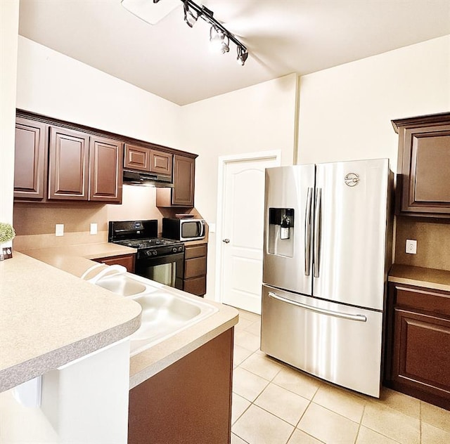 9524 SW 26th St, Oklahoma City, OK 73128 - kitchen with stainless steel appliances, track lighting, under cabinet range hood, light tile patterned floors, and light countertops