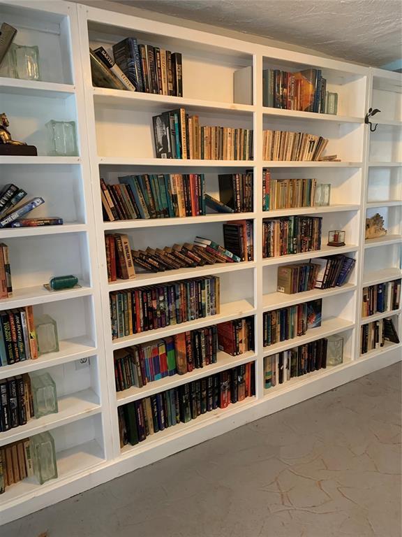 123 N Payne St, Fort Cobb, OK 73038 - living area with bookshelves and concrete flooring
