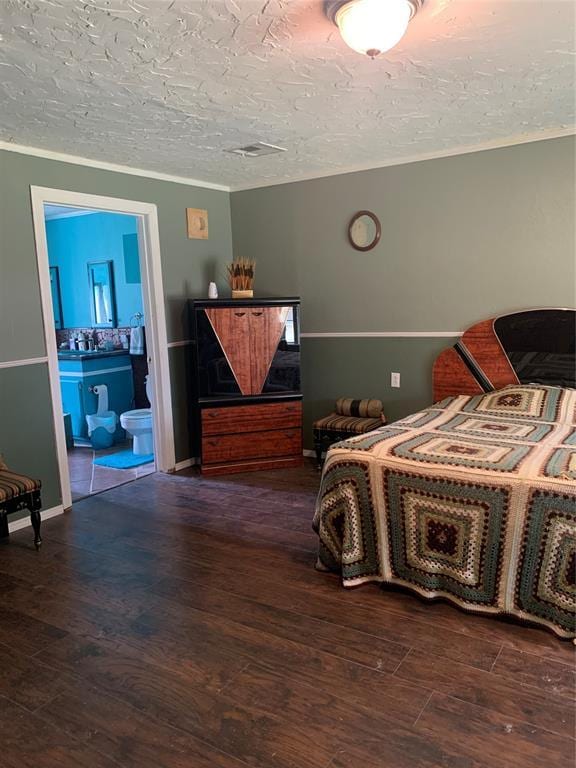 123 N Payne St, Fort Cobb, OK 73038 - bedroom with wood finished floors, a textured ceiling, and ensuite bath
