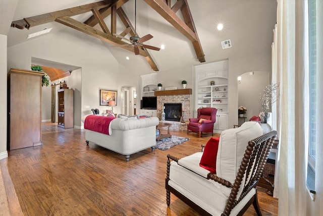 2725 Open Range Rd, Edmond, OK 73034 - living area featuring ceiling fan, arched walkways, high vaulted ceiling, beam ceiling, and a fireplace