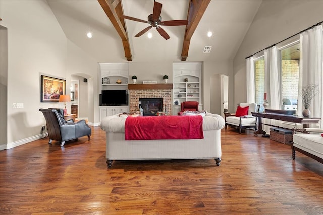 2725 Open Range Rd, Edmond, OK 73034 - living room featuring arched walkways, ceiling fan, a brick fireplace, built in shelves, and high vaulted ceiling
