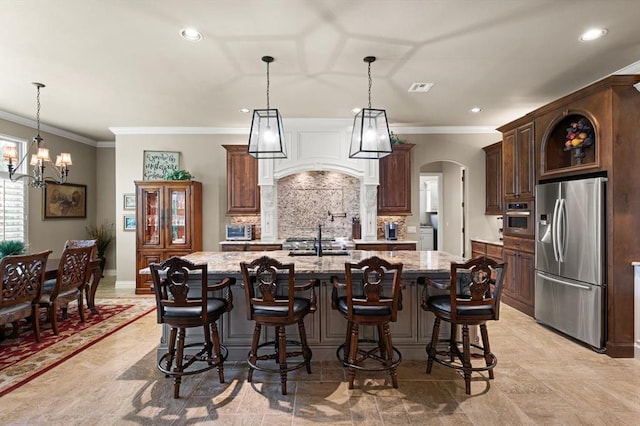 2725 Open Range Rd, Edmond, OK 73034 - kitchen with appliances with stainless steel finishes, arched walkways, ornamental molding, backsplash, and custom range hood