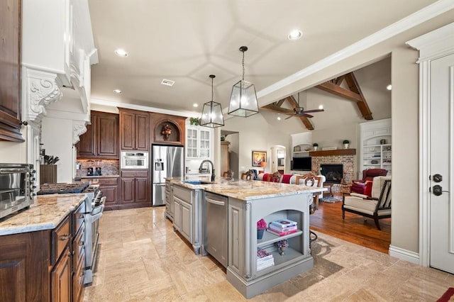 2725 Open Range Rd, Edmond, OK 73034 - kitchen with a ceiling fan, stainless steel appliances, a brick fireplace, open shelves, and a center island with sink
