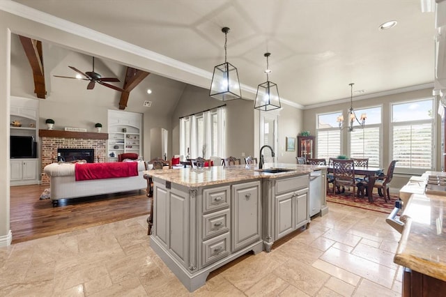 2725 Open Range Rd, Edmond, OK 73034 - kitchen featuring ceiling fan, stone tile floors, recessed lighting, an island with sink, and decorative light fixtures