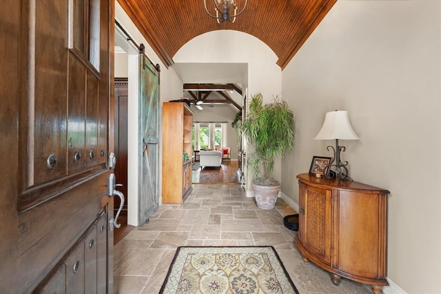 2725 Open Range Rd, Edmond, OK 73034 - foyer entrance with lofted ceiling, stone tile floors, a barn door, and wood ceiling